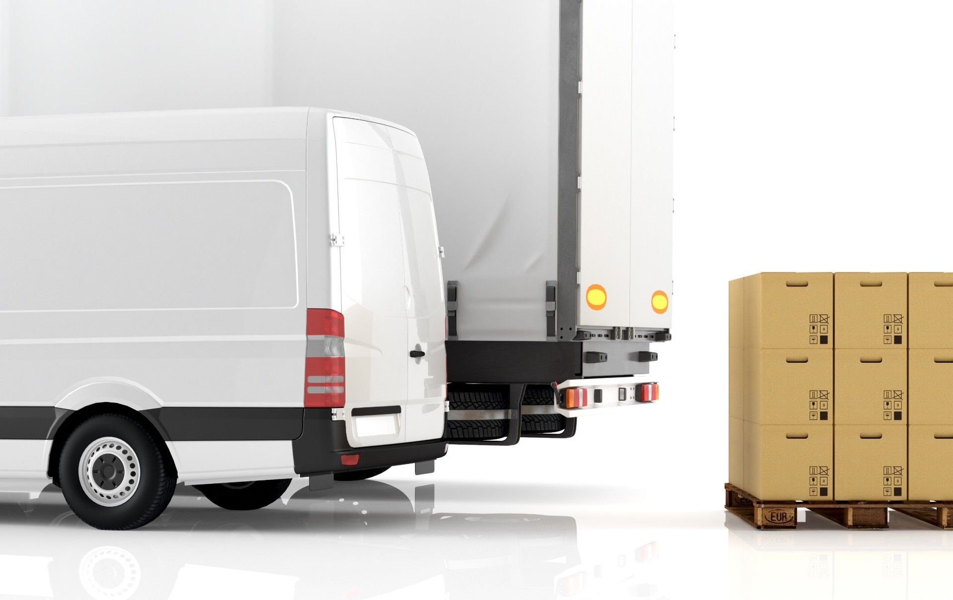 Rear view of a white delivery van and a truck alongside stacked cardboard boxes on a pallet.